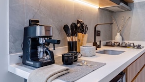 A modern kitchen with a built-in coffee maker, a sink, and a stove.