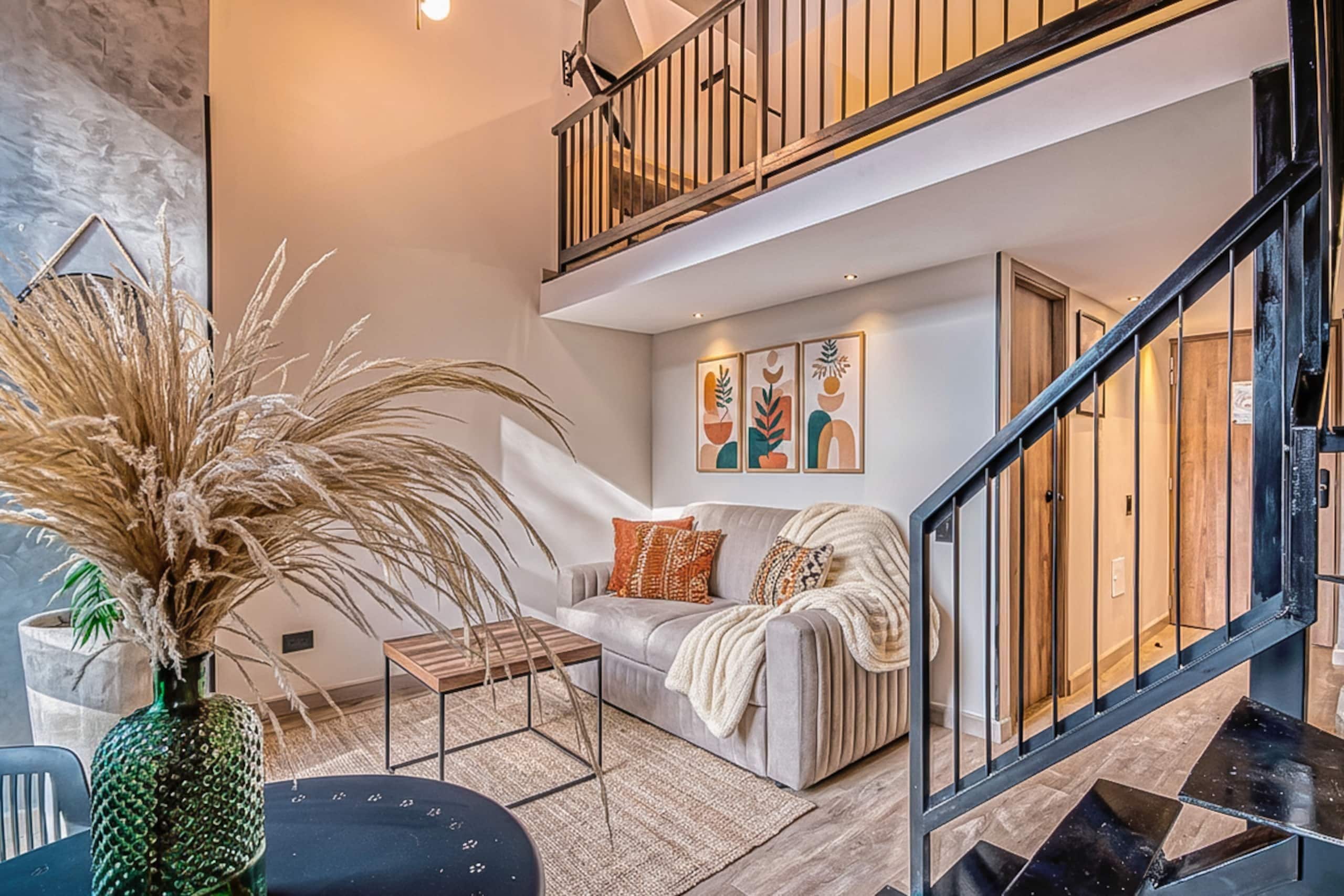 A modern living room with a sofa, a coffee table, and a potted plant.