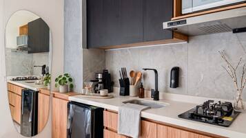 A modern kitchen with a built-in dishwasher, a coffee maker, and a gas stove.
