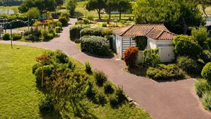 A rural landscape with a paved path, a small building with a tiled roof, and lush greenery. - Vacation apartment in Bourgenay for 4 people (Talmont-Saint-Hilaire)