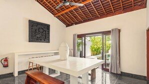 A room with a white table, wooden bench, and a ceiling fan. - Tropical Villas Jimbaran (Jimbaran)