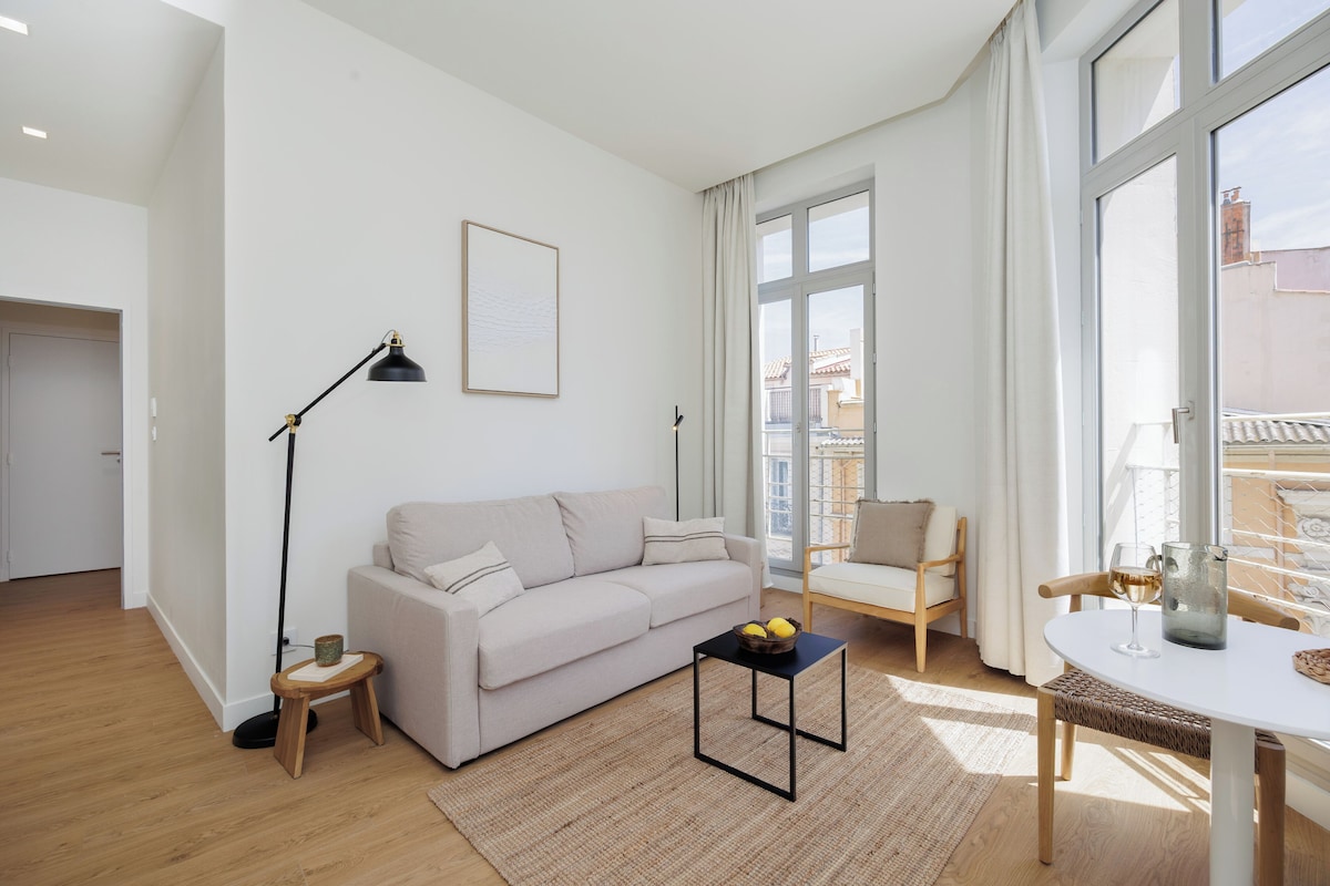 Ett modernt vardagsrum med en soffa, ett soffbord, en golvlampa och en matplats med ett bord och stolar.