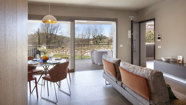 Ein modernes Interieur mit Essbereich, einer Couch und Blick ins Freie.