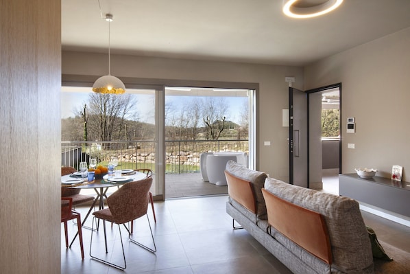 Ein modernes Interieur mit Essbereich, einer Couch und Blick ins Freie.