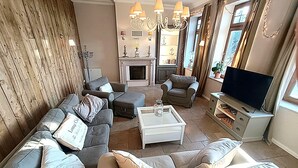 A living room with a sofa set, a coffee table, a television, and a fireplace. - Landliche Auszeit fur die Ganze Familie (Fehmarn)