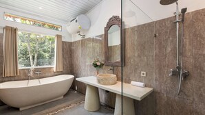 A modern bathroom with a freestanding bathtub, a large mirror, and a shower.