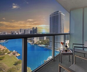 A balcony with a view of a marina and high-rise buildings. - 2BR High-Floor Suite · Waterway Views (Hallandale Beach)