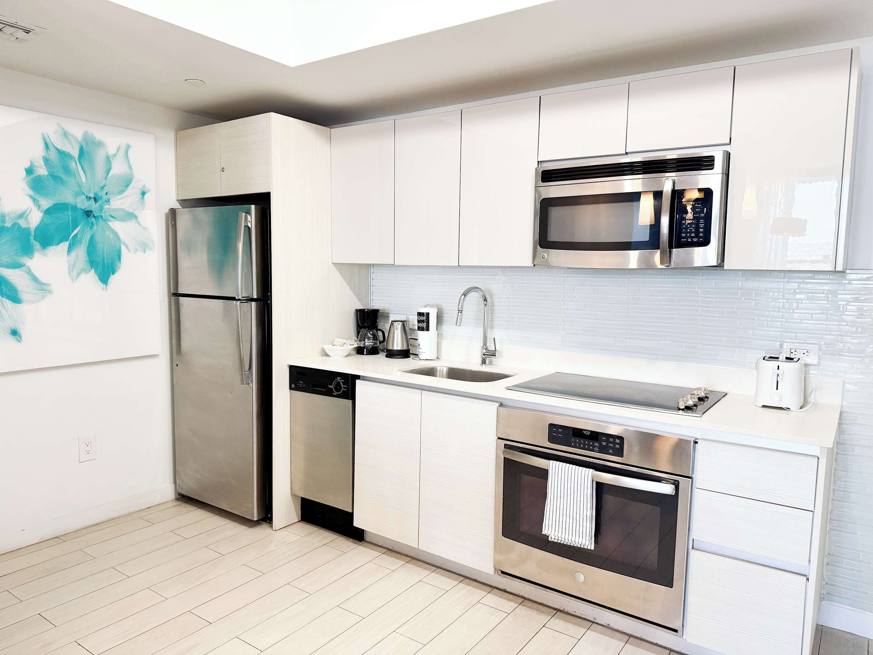 A modern kitchen with stainless steel appliances, a dishwasher, a microwave, and a toaster.