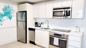 A modern kitchen with stainless steel appliances, a dishwasher, a microwave, and a toaster.