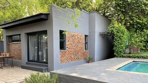 A modern house with a swimming pool, brick walls, and potted plants. - 46 on Allcock Guest Apartment & Suite (Pretoria)