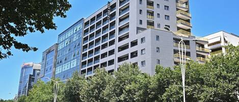 A multi-story hotel with a modern design, featuring balconies on each floor and a clear view of the surrounding area.