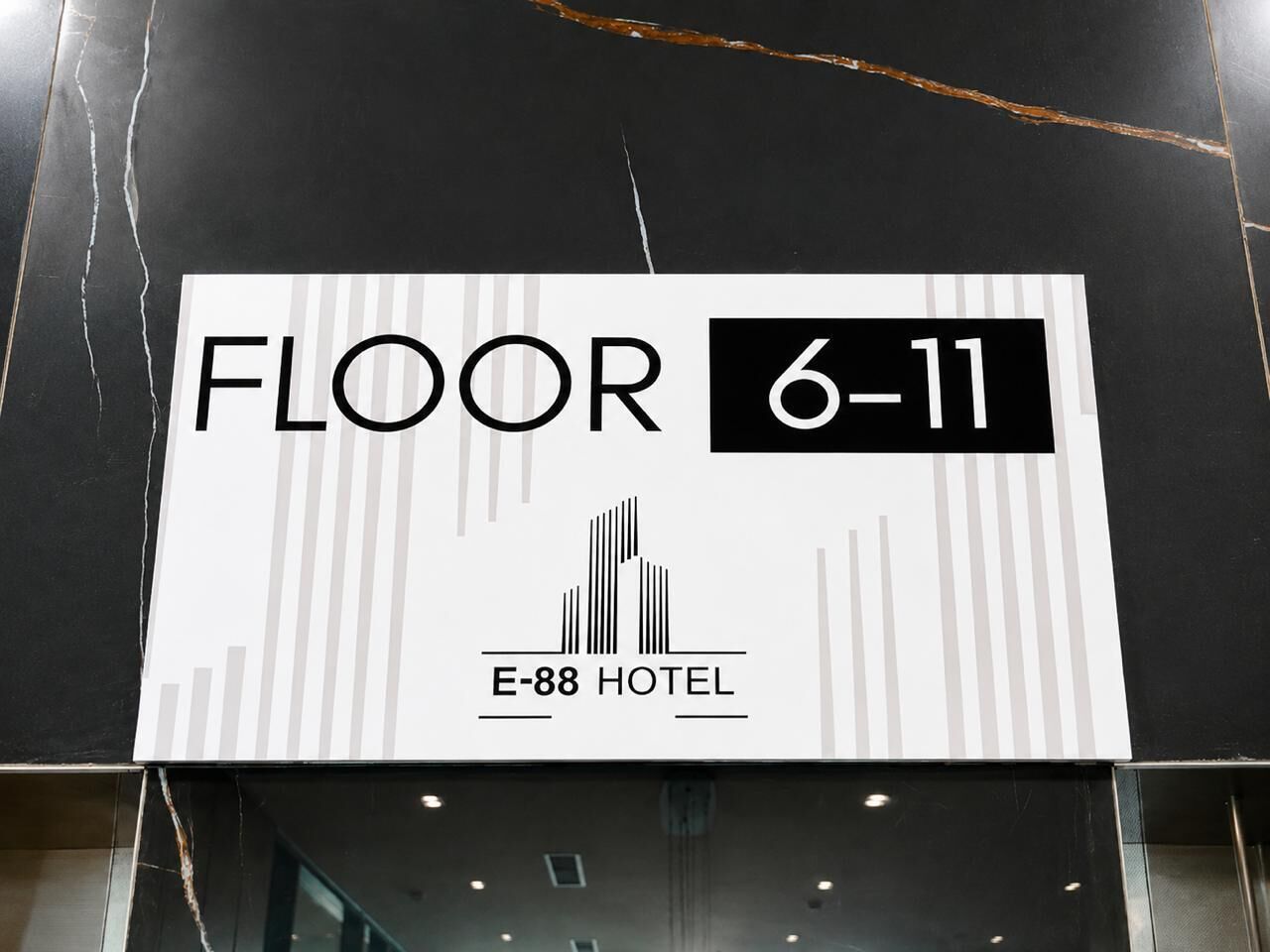 A sign indicating 'FLOOR 6-11' with the hotel name 'E-88 HOTEL' and a simple building icon.