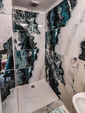 A bathroom with a unique marble tile design featuring abstract patterns. - Room-exclusive Lodge Retreat in Hartbees (Pretoria)