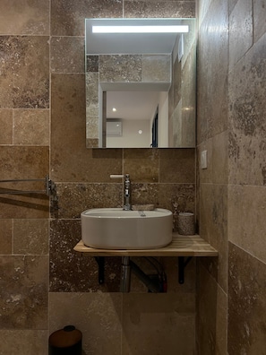 Ein Badezimmer mit Waschbecken, Spiegel und Handtuchhalter.