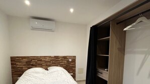Une chambre comprenant un lit, une armoire et une étagère intégrée.