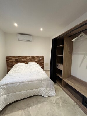 Ein Schlafzimmer mit Bett, Kleiderschrank und einer eingebauten Regaleinheit.