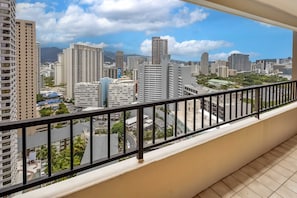 A balcony with a view of a cityscape, including high-rise buildings and a mountain in the distance. - The Moana Horizon Suite Ala Moana 28th Floor (Honolulu)