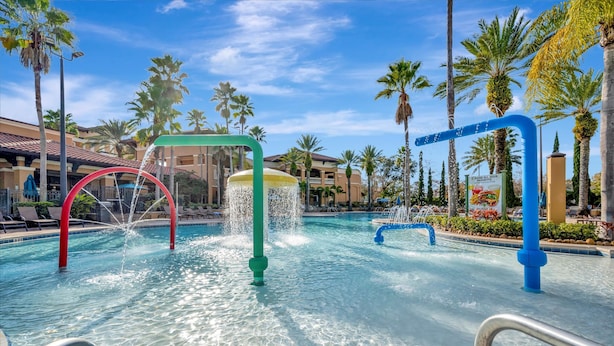 Una piscina con fuentes y palmeras.