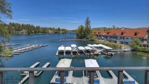 A lakeside view with docked boats, a pier, and buildings with red roofs. - Village Lakefront Paradise (Lake Arrowhead)