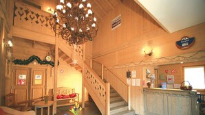 A wooden interior with a staircase, a reception desk, and a dining area. - Samoens Village Apartment for 4 (Samoëns)