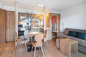 Ein modernes Interieur mit einem Holzesstisch, Stühlen, einer Couch und einem kleinen Beistelltisch.