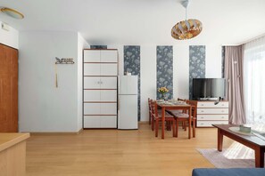 Ein modernes Wohnzimmer mit Essbereich, einem Fernseher und einer Holzkabine.