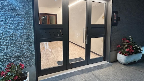 A building entrance with a glass door and a small potted plant beside it. - COMFORT ACCOMMODATION SUITE≤ CAMERE (Bergamo)