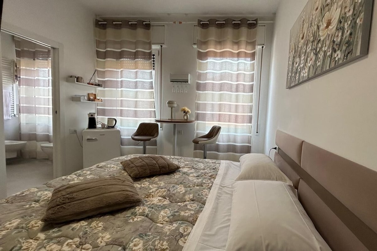 Una camera da letto con un letto, una scrivania e una sedia.