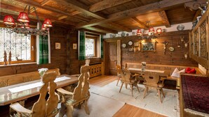 A wooden interior with a dining table, chairs, and a chandelier. - Ferienhaus Höllbacher, Mountian View & Garden (Bad Gastein)