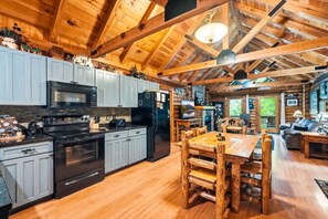 Ein Holzblockhaus mit Küche, Essbereich und Wohnzimmer.