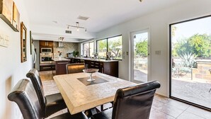 Eine moderne Küche mit Essbereich, großen Fenstern und einem Deckenventilator.