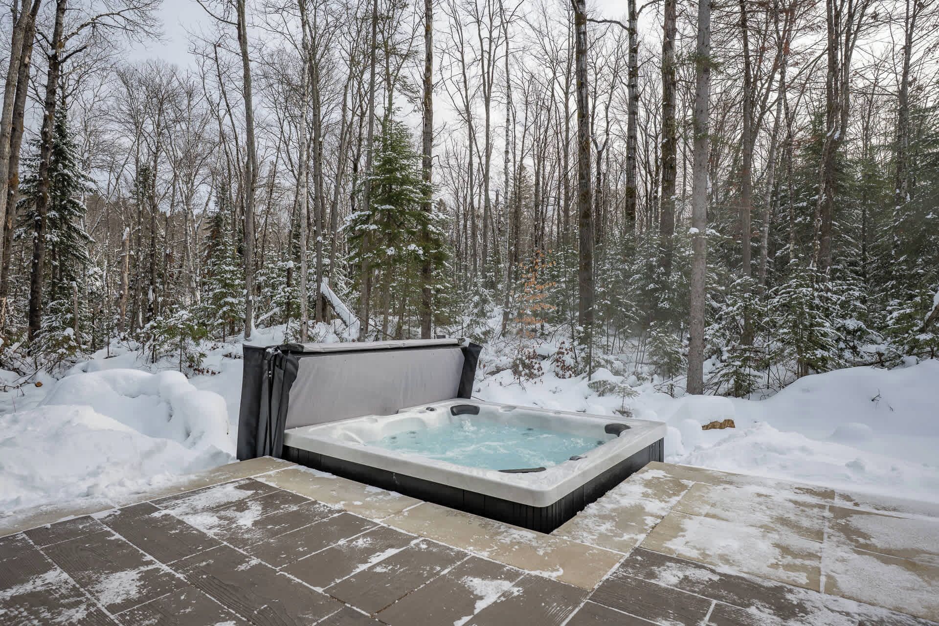 Ein Whirlpool inmitten eines verschneiten Waldes.