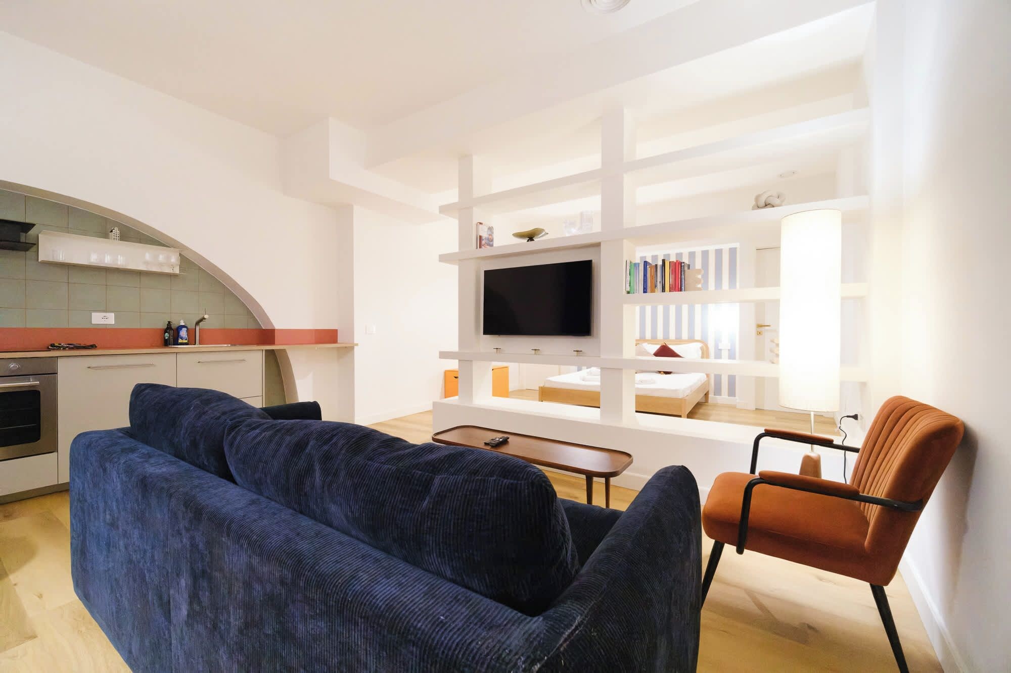 A modern living room with a sofa, a television, and a bookshelf.