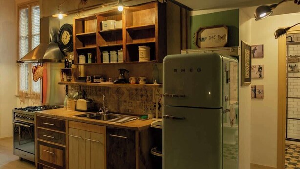A kitchen with a stove, sink, refrigerator, wooden cabinets, and a clock on the wall. - BuddyRent - Lucky Jazz - Nomentana - 5 ospiti (Rome)