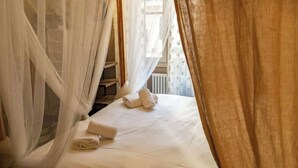 A bedroom with a bed, a rolled-up towel, and a canopy. - BuddyRent - Lucky Jazz - Nomentana - 5 ospiti (Rome)