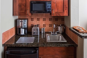 A kitchen with a microwave, coffee maker, toaster, sink, and cabinets. - Hyatt Pinon Pointe (Sedona)