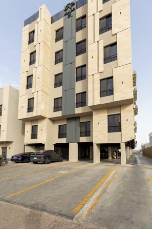 Ein mehrstöckiges Gebäude mit modernem architektonischem Design, das ein zentrales, vertikales Element und mehrere Balkone aufweist.