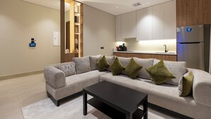 Uma sala de estar moderna com um sofá seccional, uma mesa de centro e uma estante embutida de madeira.