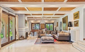 A spacious living room with a high ceiling, large windows, and a fireplace. - Grand Marbella Estate with tropical gardens (Marbella)