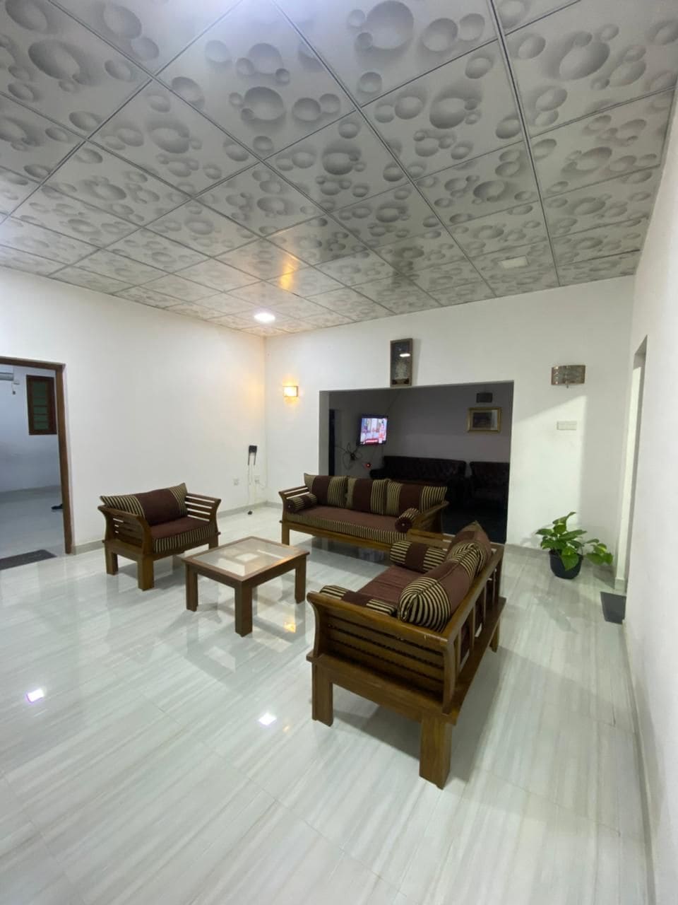 A living room with a sofa set, a coffee table, and a television.