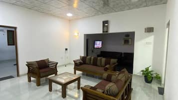 A living room with a sofa set, a coffee table, and a television.