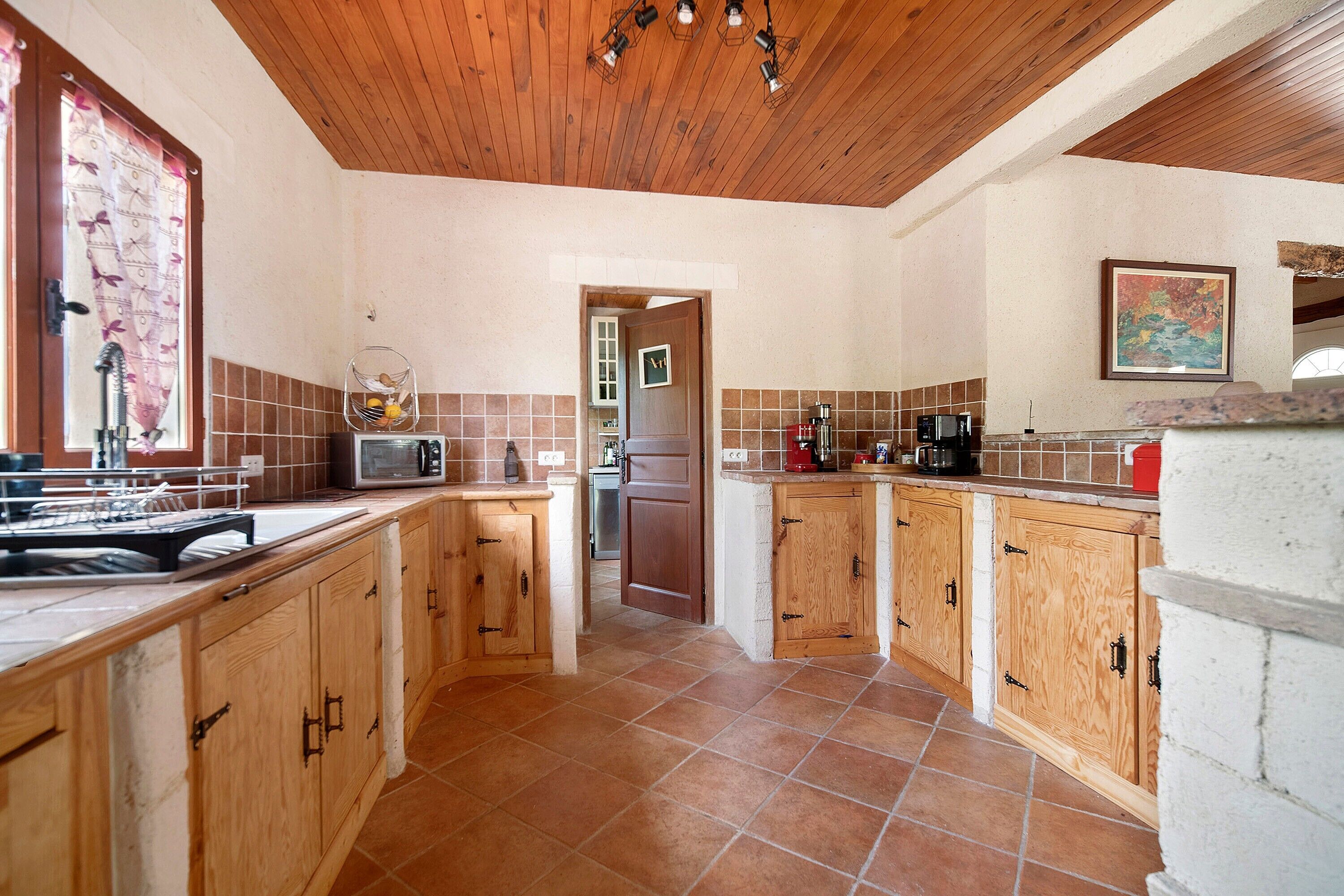 A kitchen with wooden cabinets, a microwave, and a coffee maker.