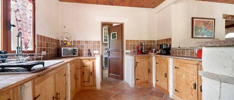 A kitchen with wooden cabinets, a microwave, and a coffee maker.