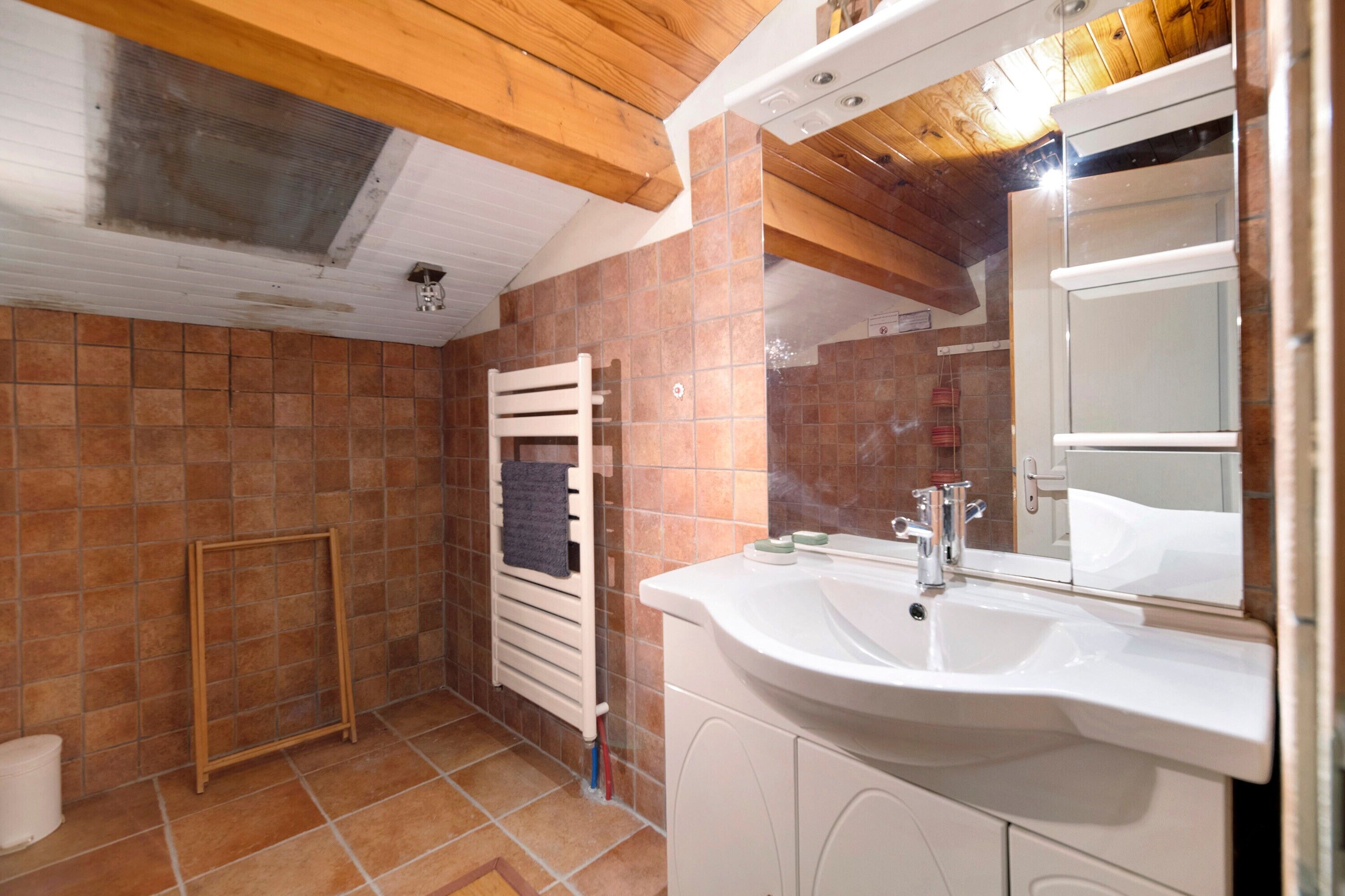 A bathroom with a white sink, a mirror, and a towel rack.