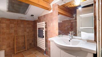 A bathroom with a white sink, a mirror, and a towel rack.