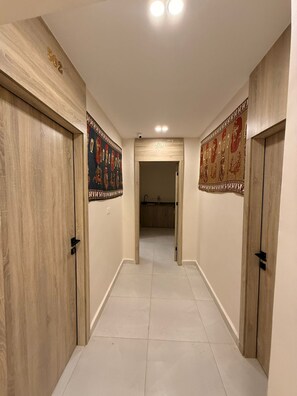 Un passadís amb portes de fusta, numerades 502 i 501, que condueix a un bany.