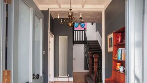 A hallway with a radiator, a staircase, and a bookshelf. - Beautiful apartment for 2 people with A/C, WIFI, TV and pets allowed (Falmouth)