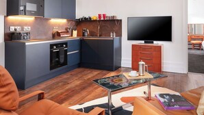 A compact living space with a kitchenette, a flat-screen TV, a coffee table, and a sofa. - Beautiful apartment for 2 people with A/C, WIFI, TV and pets allowed (Falmouth)