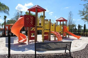 Ein Spielplatz mit Rutschen und einer Bank.