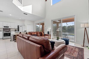 Enjoy the charm of this spacious living area, complete with inviting leather sofas and abundant natural light from large sliding doors, highlighting cozy furnishings and tasteful decor for a warm, welcoming atmosphere. - 6BR house sleeps 14 with private pool (Kissimmee)